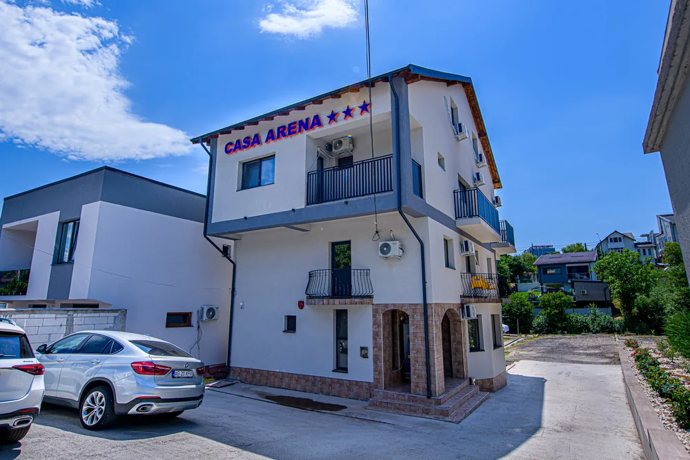 Casa Arena văzută din curte, cu mașini parcate în față